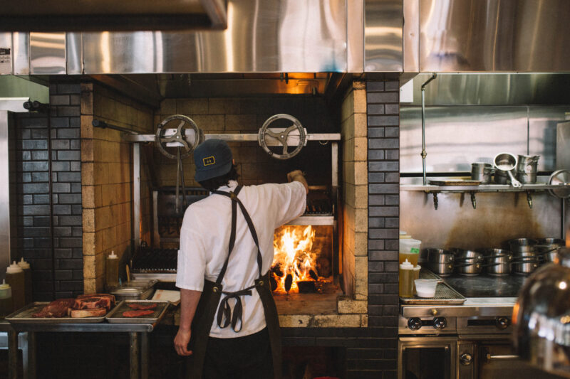 A cook at our hotel in downtown Minneapolis preparing food over an open flame