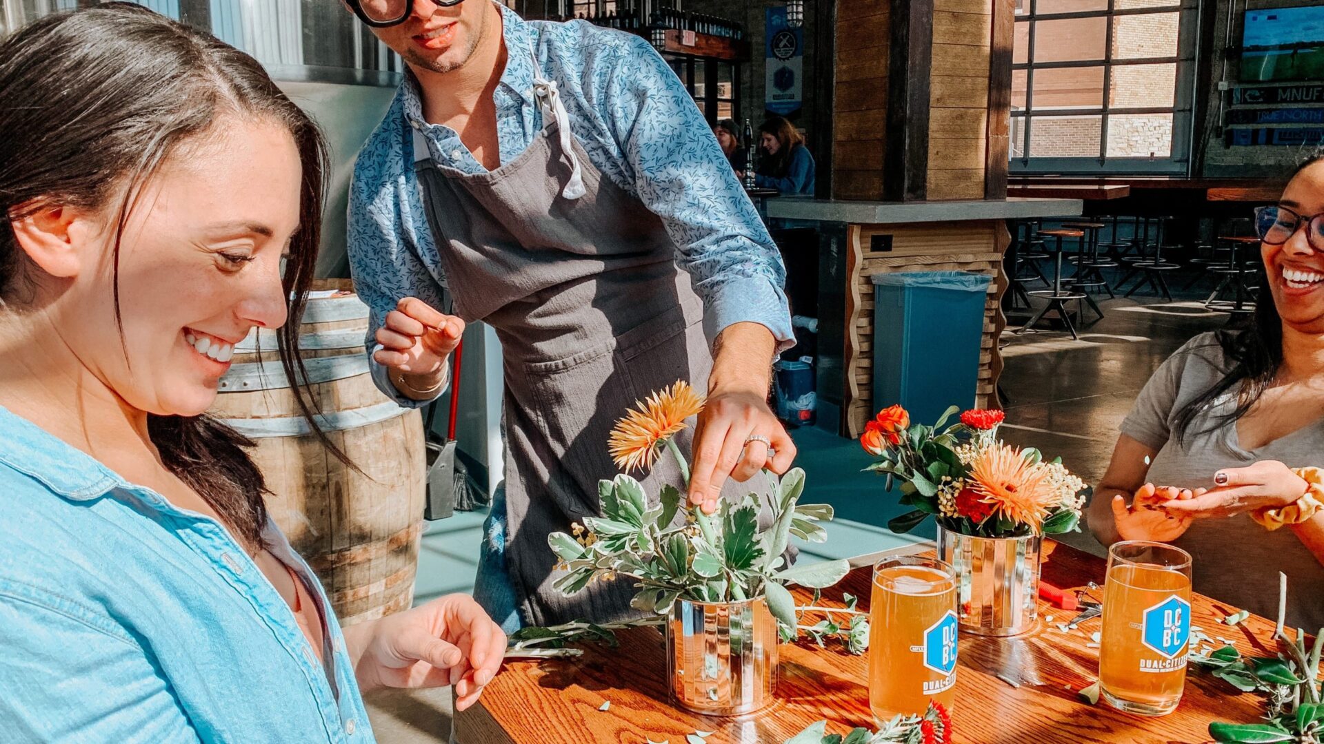 Man arranging flowers for two women at our Minneapolis boutique hotel