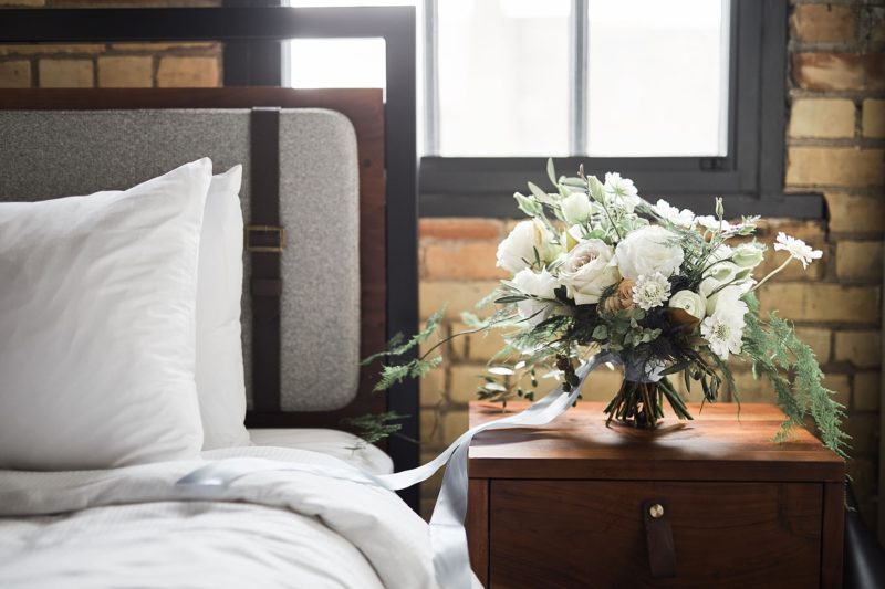 White floral arrangement next to a bed at our Minneapolis downtown hotel