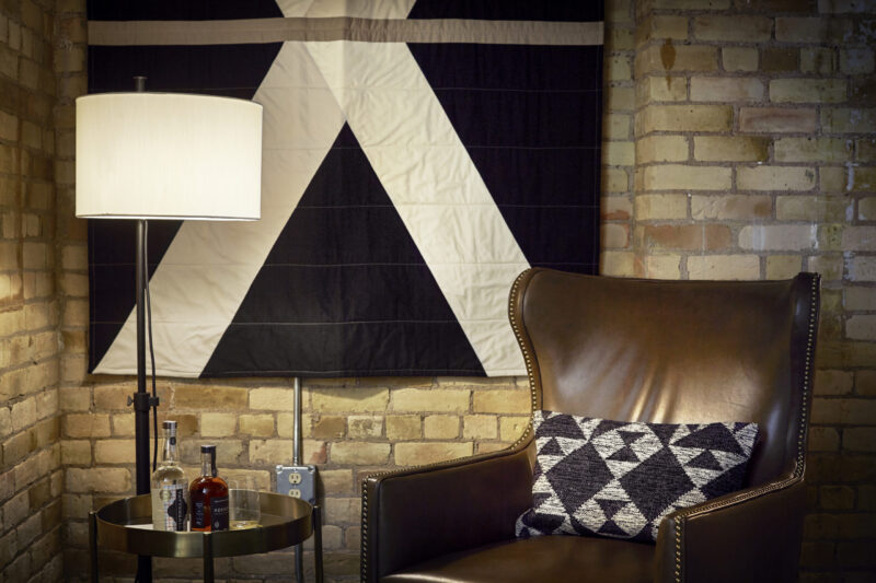 Leather chair next to a liquor tray in front of a brick wall at our hotel in Minneapolis