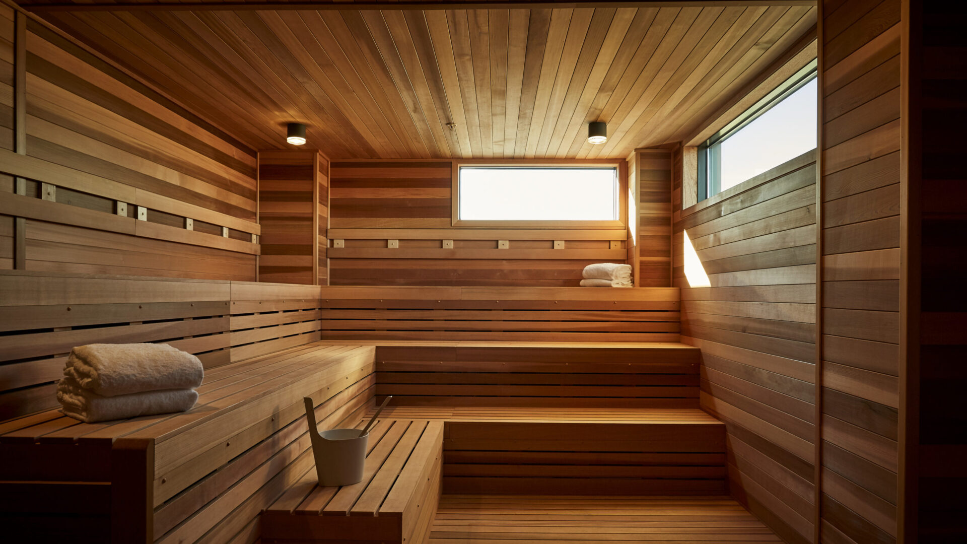 Wooden sauna with raised benches and small windows at our Minneapolis hotel