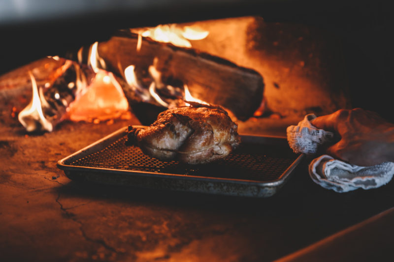 Whole chicken being cooked over a fire at our downtown Minneapolis hotel