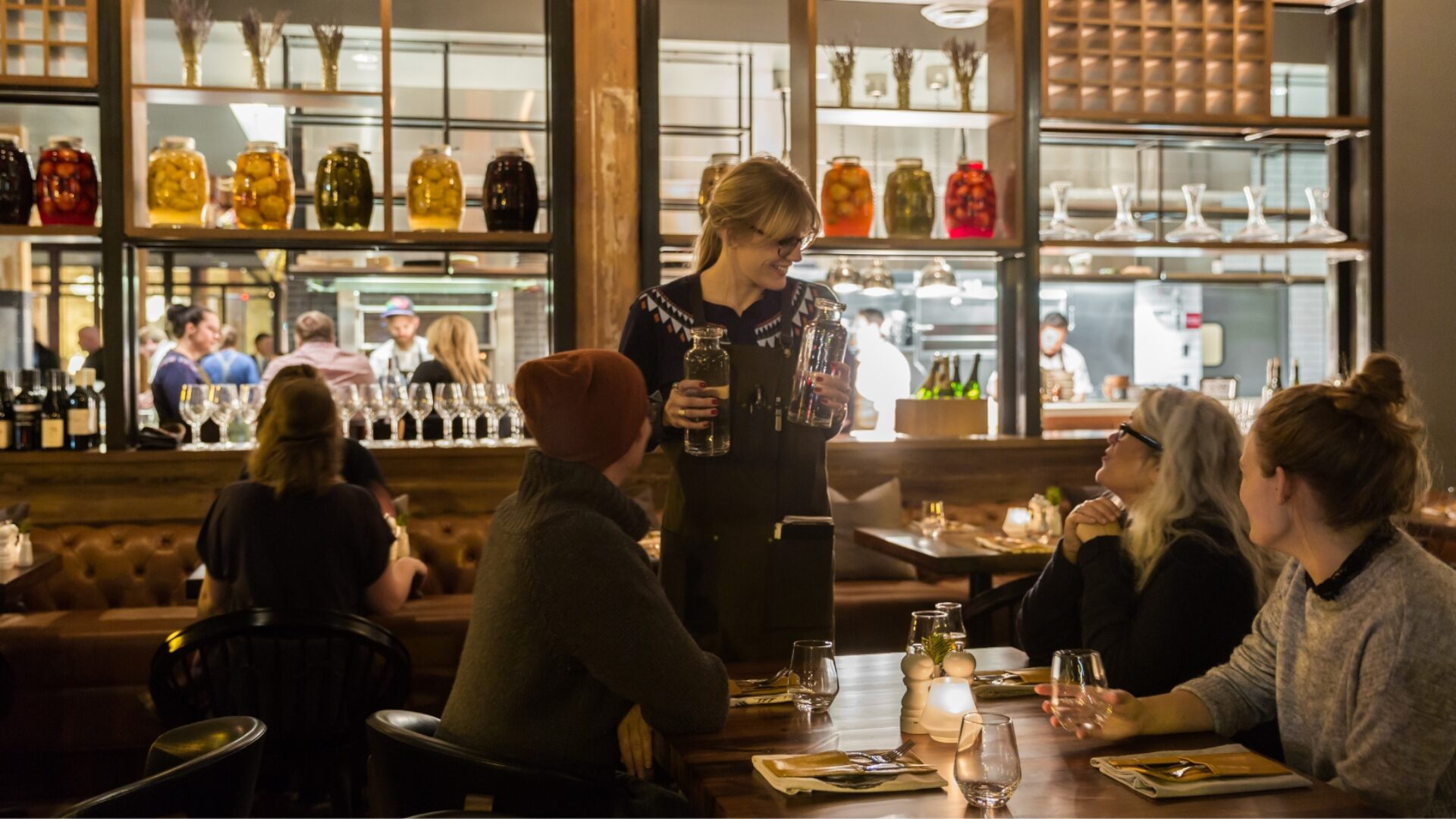 Waitress serving a table in mood lighting at our North Loop restaurant