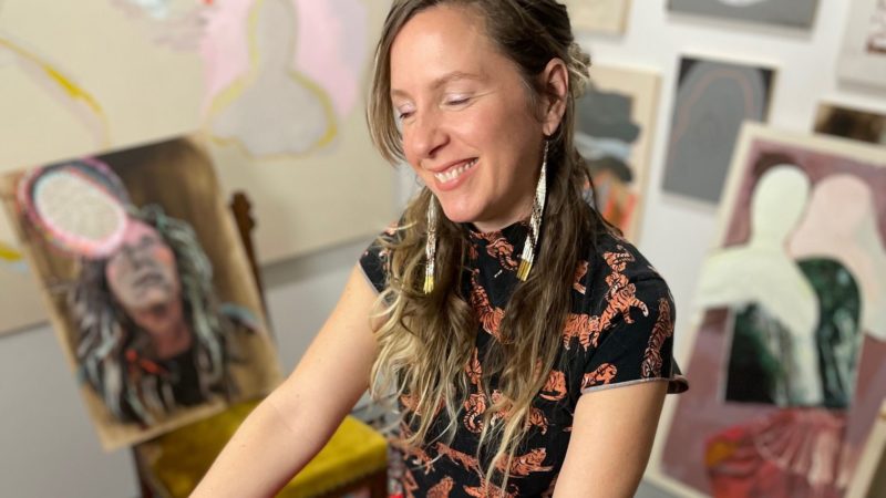 Image of a smiling female artist in red at our downtown Minneapolis hotel